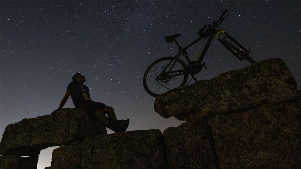 Một người đi xe đạp ngắm mưa sao băng Perseid phía trên lâu đài Zerzevan ở Diyarbakir, Thổ Nhĩ Kỳ, đêm 12.8. Một sao băng có thể nhìn thấy ở sau bánh sau của chiếc xe đạp. Ảnh: AFP/Getty