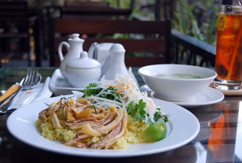 Cơm gà Hội An, số 1A Cửa Đông, Hoàn Kiếm, Hà Nội. Cơm gà Hội An được ăn với dưa góp, mà dưa góp này phải được rưới thêm chút dấm cho thơm nồng. Cơm gà Hội An đơn giản nhưng trông vẫn hấp dẫn và đặc biệt. Hạt cơm nhỏ, có màu vàng tươi như xôi vò, thịt gà đã lọc xương được xếp gọn gàng một góc, trên cùng là dưa góp với chút rau mùi.