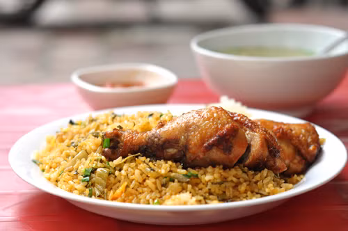 Cơm rang gà quay phố Bà Triệu. Quán nằm ngoài mặt đường, đoạn gần ngã tư giao nhau của 2 trục phố chính này. Một suất cơm rang gà quay ở đây luôn kèm một đĩa dưa góp giải ngấy, một bát nước dùng chống khô khan, cùng một chén nước sốt.