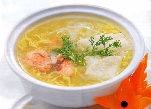 Súp bóng cá thịt cua. Bóng cá thái hạt lựu. Thịt cua trộn với hành tây, 1 thìa cà-phê dầu vừng, 1/3 thìa cà-phê tiêu để bớt tanh. Cho xương gà vào nồi hầm với 2.5 lít nước, vớt bọt liên tục cho nước trong. Thịt mềm, bỏ xương, nêm hạt nêm vào nước dùng cho vừa ăn.