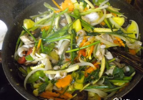 Sau đó trút bong bóng ra đĩa khác. Tiếp tục cho chảo dầu nóng già, phi thêm hành tỏi băm nhỏ lần lượt cho nấm hương, cà rốt, ngô non, đậu hà lan, cần tây, hành hoa cho sau cùng nêm nếm gia vị vừa ăn, đảo nhanh tay cho các nguyên liệu chín đều.