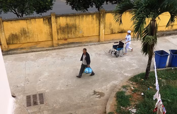 Một côn đồ đang xách cơm vào bệnh viện.