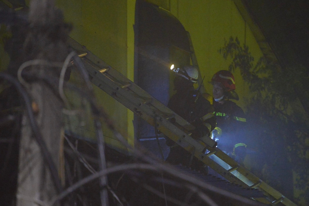 Lực lượng PCCC phải dùng thang, dụng cụ để phá tường, tiếp cận hiện trường.