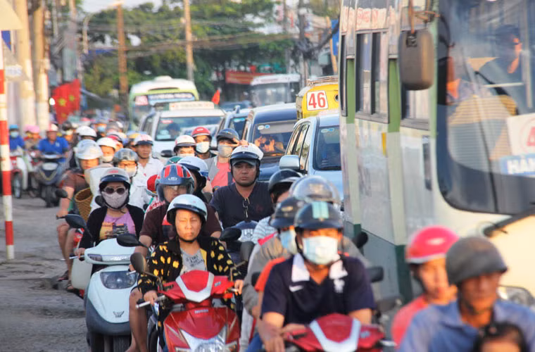 Dòng xe máy, ô tô, xe buýt nối đuôi nhau trên đường Nguyễn thị Định để ra đại lộ Đông Tây.