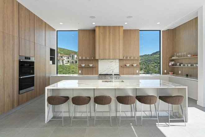 Nhà bếp sáng sủa, thông thoáng, được trang bị các công cụ nấu nướng hiện đại và nội thất làm từ gỗ óc chó.