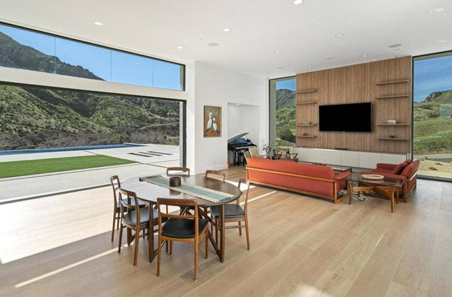 Phòng khách và khu vực ăn uống được tích hợp trong một không gian rộng lớn, cởi mở, nổi bật với sàn gỗ sồi Pháp.