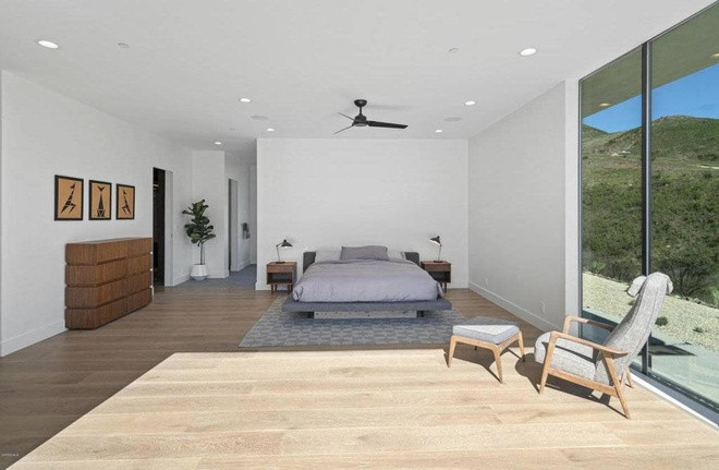 Phòng ngủ chính sang trọng, thoáng đãng, tràn ngập ánh sáng tự nhiên, được bài trí theo phong cách tối giản.