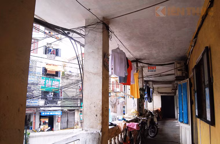 Hành lang cũ mèm, trần nhà rêu mốc và ngấm nước là nơi phơi quần áo, nấu ăn và để đồ của những hộ dân sinh sống tại đây.