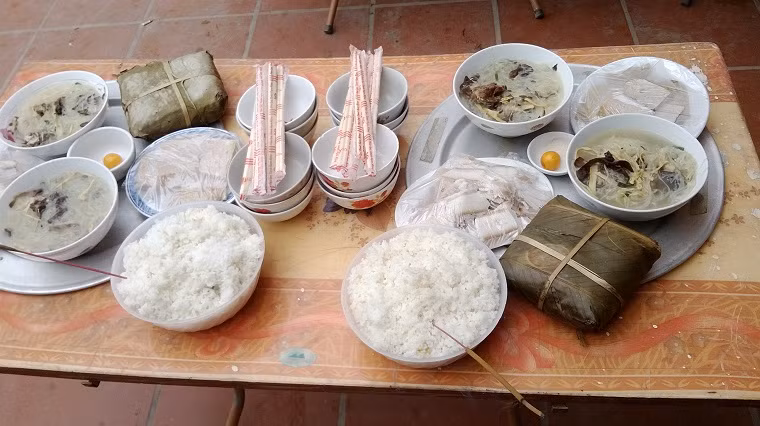Mâm cơm thết đãi khách có bánh chưng, cơm, miến, giò, trứng gà...