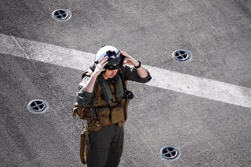 br/> Một phi công của USS Portland kiểm tra thiết bị trước khi cất cánh trên một chiếc trực thăng MH-60.