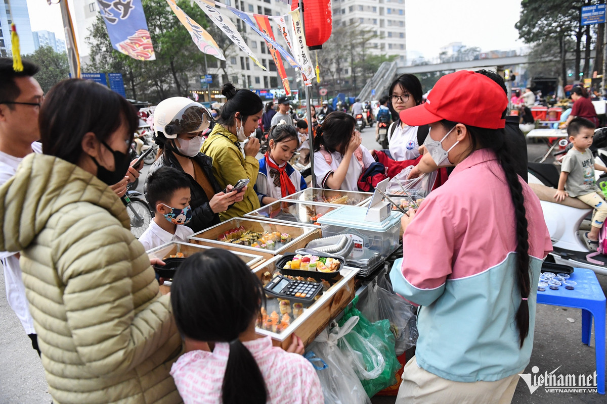Hàng quán cũng tràn cả xuống lòng đường, vỉa hè vì sức mua rất lớn. Các quầy đồ ăn đều chật cứng khách hàng.
