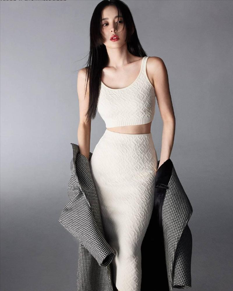 ỹ nhân Tân Cương lăng xê mốt chân váy dệt kim mix cùng áo crop top đồng chất khoe eo thon và đường cong gợi cảm. Người đẹp khéo léo kết hợp bên ngoài áo khoác dạ sang chảnh.