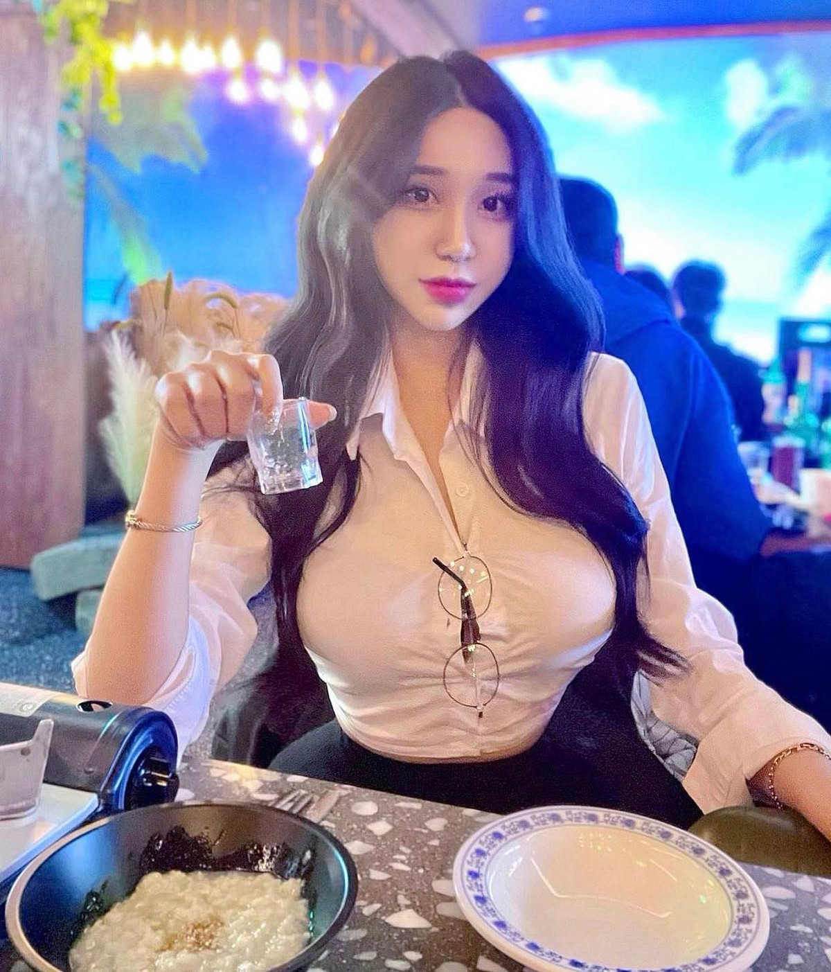  Mới đây, một người đẹp Hàn Quốc nổi tiếng trên mạng xã hội thu hút nhiều sự chú ý khi đi ăn hàng với trang phục công sở bắt mắt bao gồm áo sơ mi trắng kết hợp chân váy mini juyp đen. Được biết, cô gái này tên là Kim Hyun Young, hiện đang làm tiếp viên cho hãng hàng không tại Hàn Quốc. Kiểu áo sơ mi dài tay, dáng ngắn, nhưng ôm sát cơ thể, kết hợp mốt bung cúc, giúp tôn vòng 1 đã từng được cô chưng diện rất nhiều lần trước đó. Ảnh: Kim Hyun Young diện áo sơ mi bung cúc, khoe khéo vòng 1 đẹp.