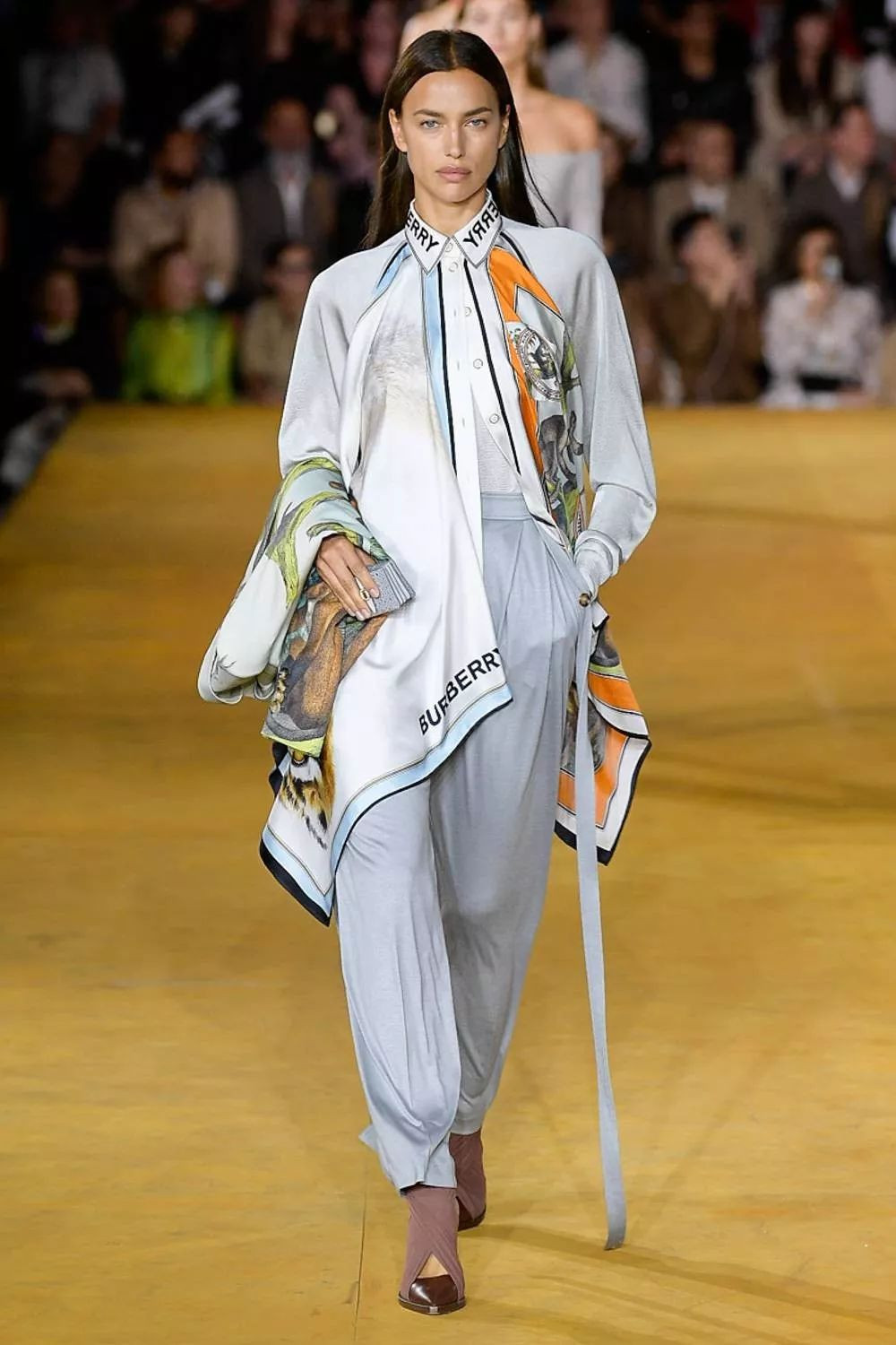 Ngày nay, những chiếc áo sơ mi phá cách đã không còn bó hẹp trong môi trường công sở mà được rất nhiều các nhà thiết kế đưa vào BST của mình tạo nên một sự lệch pha thú vị nhưng không kém phần duyên dáng trên sàn diễn thời trang. Ảnh: BST Xuân - Hè 2020 của Burberry với cách mặc sơ mi lệch pha mà không kém phần thú vị.