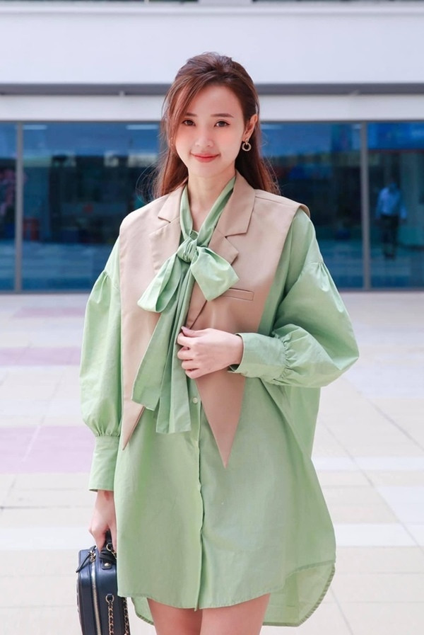 Midu xuất thời thượng trong thiết kế sơ mi tay bồng cùng chi tiết cổ nơ với tông xanh mát mắt. Lựa chọn những tông màu tươi sáng, nhã nhặn, hình ảnh của Midu trở nên trong sáng và trẻ trung trong mắt học trò.