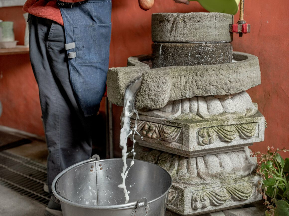 Xưởng của ông Liu biểu diễn cách làm đậu thủ công theo phương thức truyền thống để khách tham quan hiểu rõ hơn về sự khác biệt. Đậu được ngâm qua đêm và sau đó xay bằng cối đá.