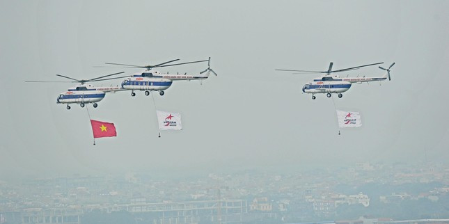 Trực thăng vũ trang treo cờ Việt Nam và cờ triển lãm bay biểu diễn. Ảnh: Trọng Tài