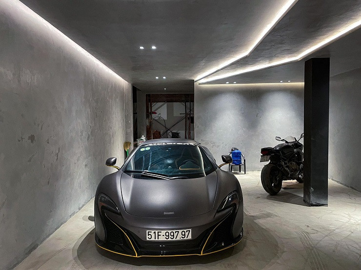 Tầng trệt là nơi để chiếc xe McLaren 650S và xe môtô đắt giá của Quốc Anh. “Là một người có đam mê với siêu xe, mình muốn khi bước vào garage là phải thật chỉn chu, cho nên đã dành riêng tầng trệt để lên kế hoạch và thiết kế theo tone màu xám bê tông theo hơi hướng hiện đại” – Quốc Anh chia sẻ.