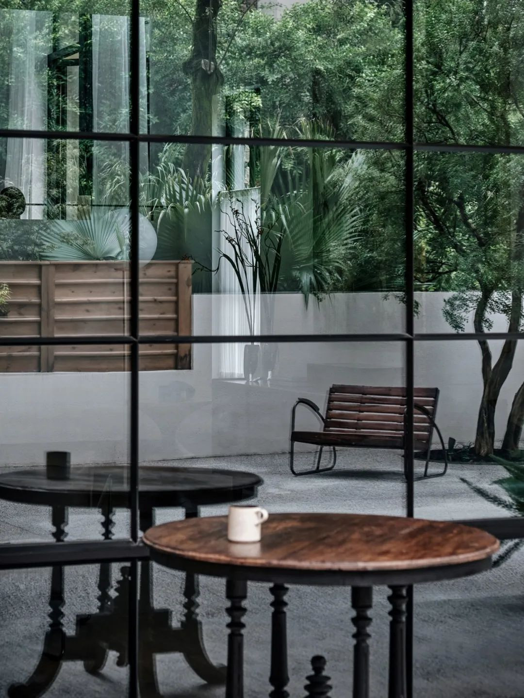 Phòng khách có view ra khu vườn, nhìn ra các ô kính có khung thép đen. Đây là ý tưởng của Yu Ling lấy cảm hứng từ khách sạn cổ ở Pháp. Với thiết kế này, cô mong căn nhà đơn giản, gắn với thiên nhiên mà vẫn ấm áp và dễ chịu