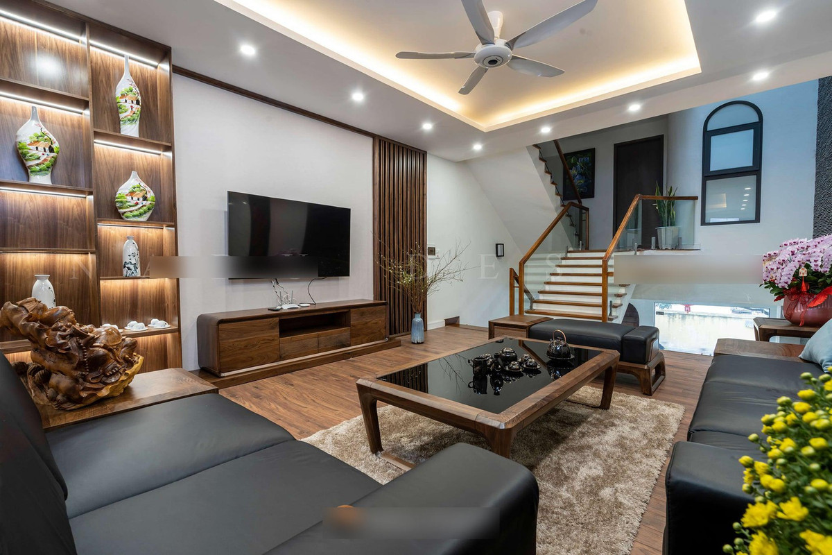 Ở phòng khách còn đặt một kệ gỗ lớn để trưng bày nhiều bình gốm quý, giúp thỏa mãn đam mê của gia chủ.