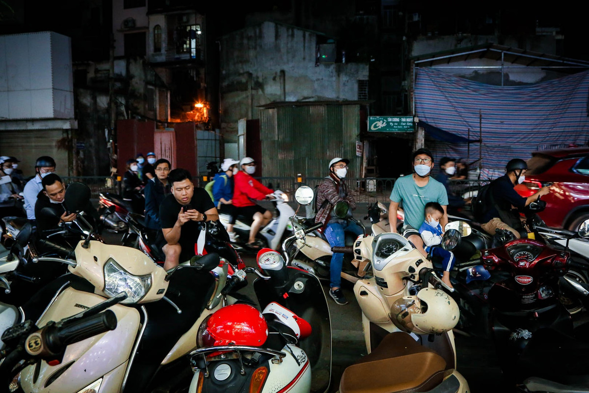 Nhiều người phải xếp thành hàng theo sát lề đường và ngồi chờ bạn gái "săn" đồ giảm giá.