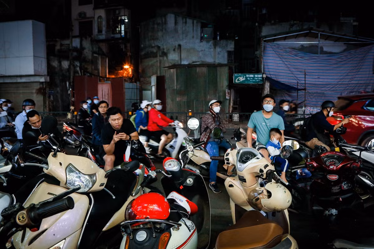 Nhiều người phải xếp thành hàng theo sát lề đường và ngồi chờ bạn gái "săn" đồ giảm giá.