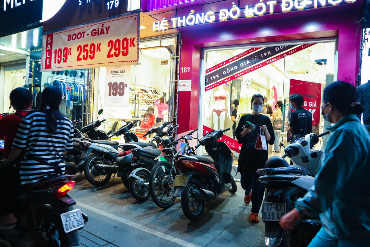 Trái ngược với không khí khá ảm đạm tại nhiều địa điểm mua sắm ở quận Cầu Giấy, con đường mua sắm Chùa Bộc (quận Đống Đa) lại càng nhộn nhịp khi về đêm. Nhiều cửa hàng tại đây áp dụng chiến dịch đồng giá thay vì giảm giá theo % để thu hút khách hàng.