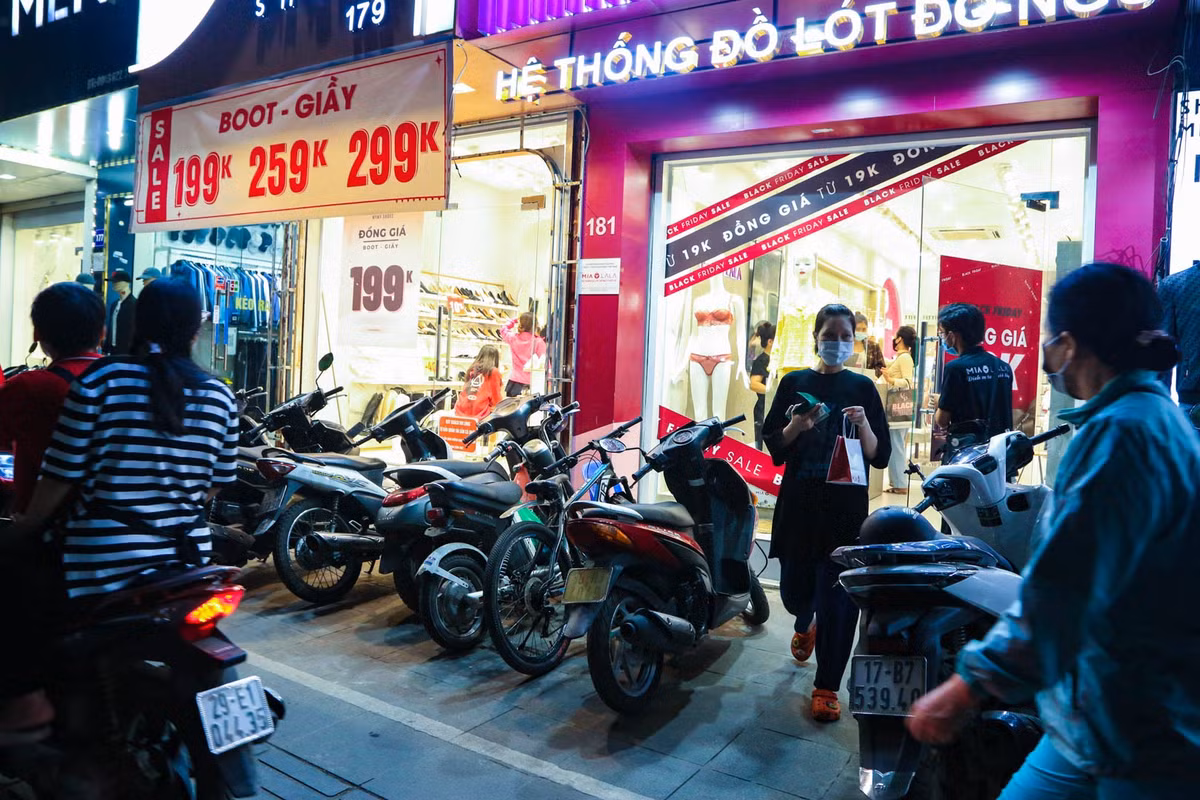 Trái ngược với không khí khá ảm đạm tại nhiều địa điểm mua sắm ở quận Cầu Giấy, con đường mua sắm Chùa Bộc (quận Đống Đa) lại càng nhộn nhịp khi về đêm. Nhiều cửa hàng tại đây áp dụng chiến dịch đồng giá thay vì giảm giá theo % để thu hút khách hàng.