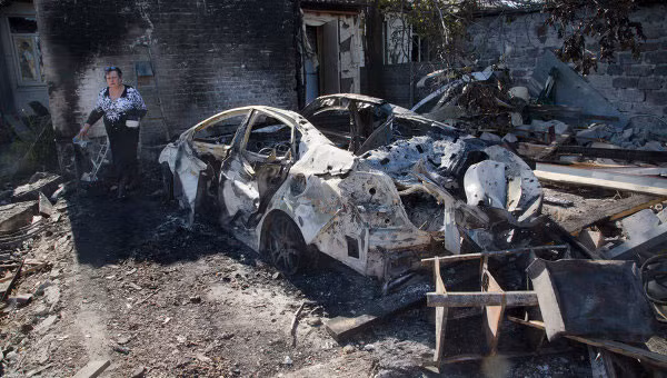 Xe ô tô và nhà cửa bị cháy rụi sau khi trúng pháo. (Ảnh minh họa)