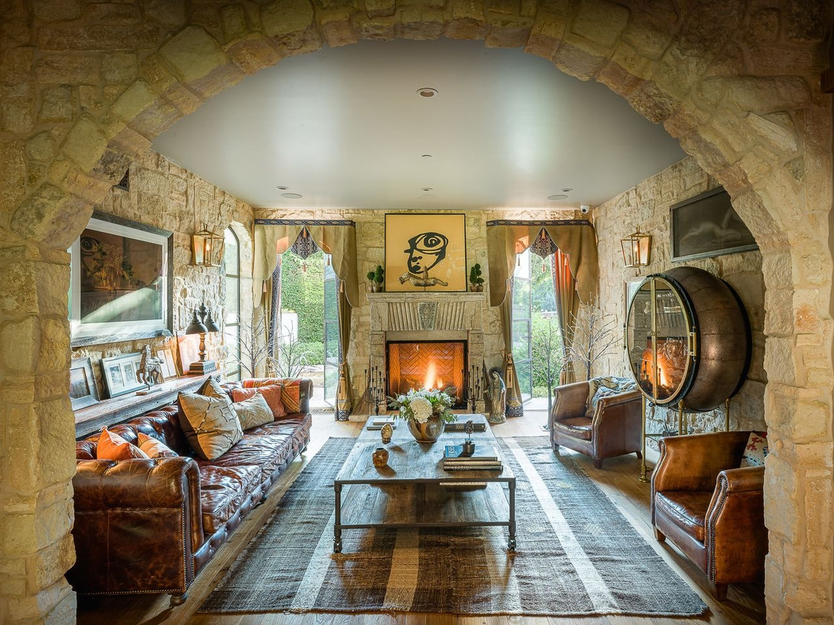 Một cổng tò vò nhân tạo làm bằng đá dẫn đến không gian phòng khách ấm cúng. Ánh sáng tự nhiên được khai thác tối đa thông qua cửa kính của căn nhà.
