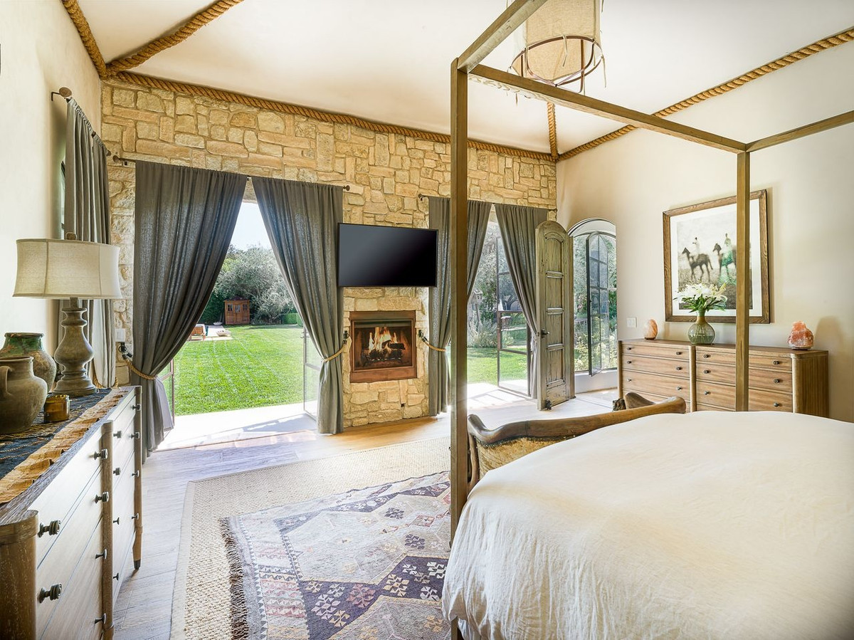 Phòng ngủ được trang bị lò sưởi cùng những cánh cửa kiểu Pháp để tô điểm thêm sự lãng mạn cho không gian.