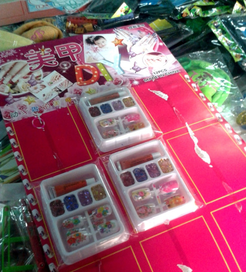 Hộp móng tay giả và keo dùng dán móng được bán cho trẻ em, tại căng tin một trường tiểu học quận Gò Vấp, TPHCM.