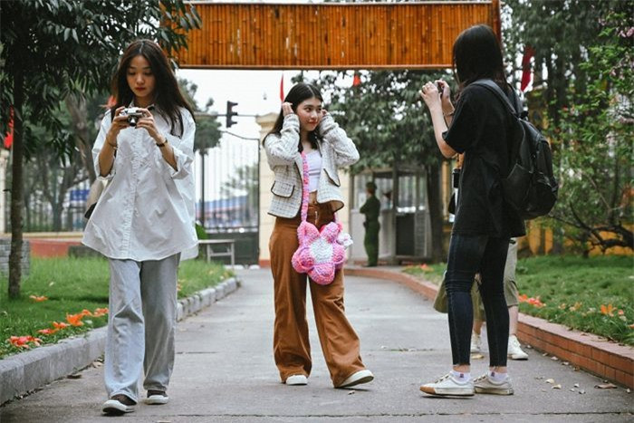 Những bông hoa gạo rụng dưới thảm cỏ cũng tạo nên ý nghĩa riêng, thu hút nhiều bạn trẻ.