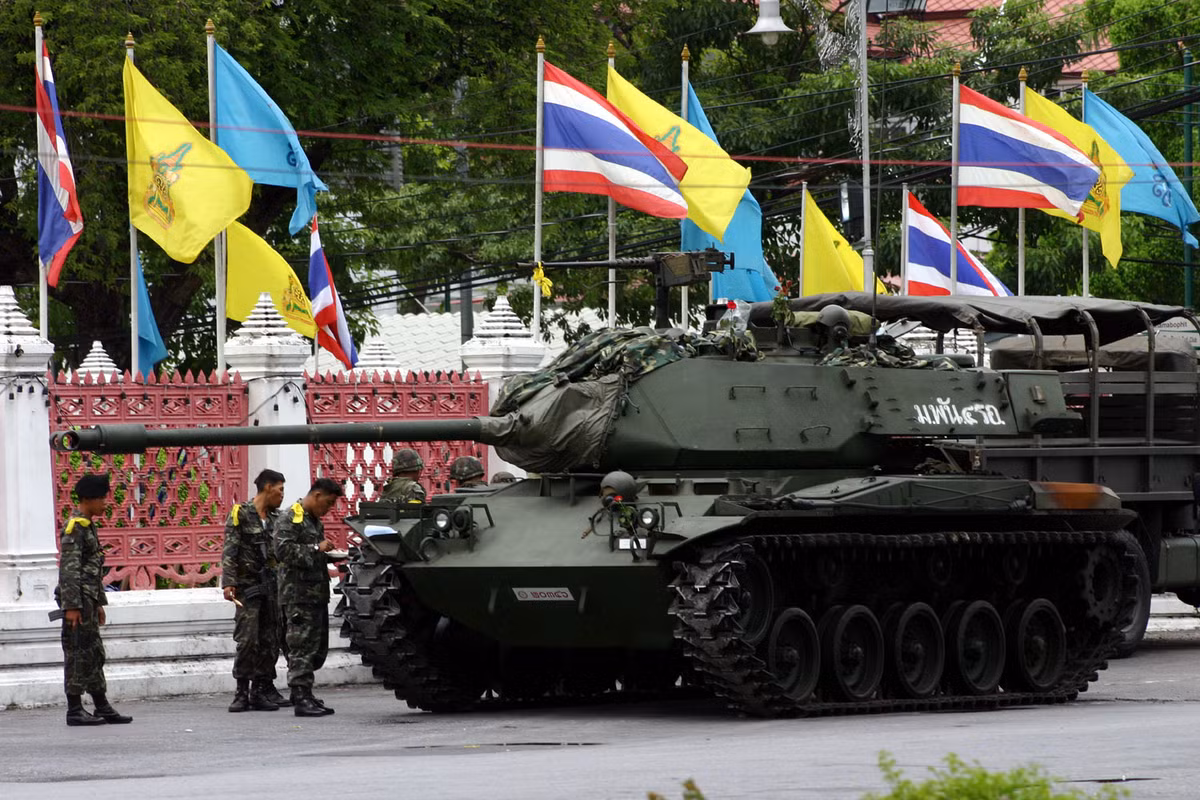 Nhóm binh sĩ Thái Lan đứng bên cạnh một chiếc xe tăng.