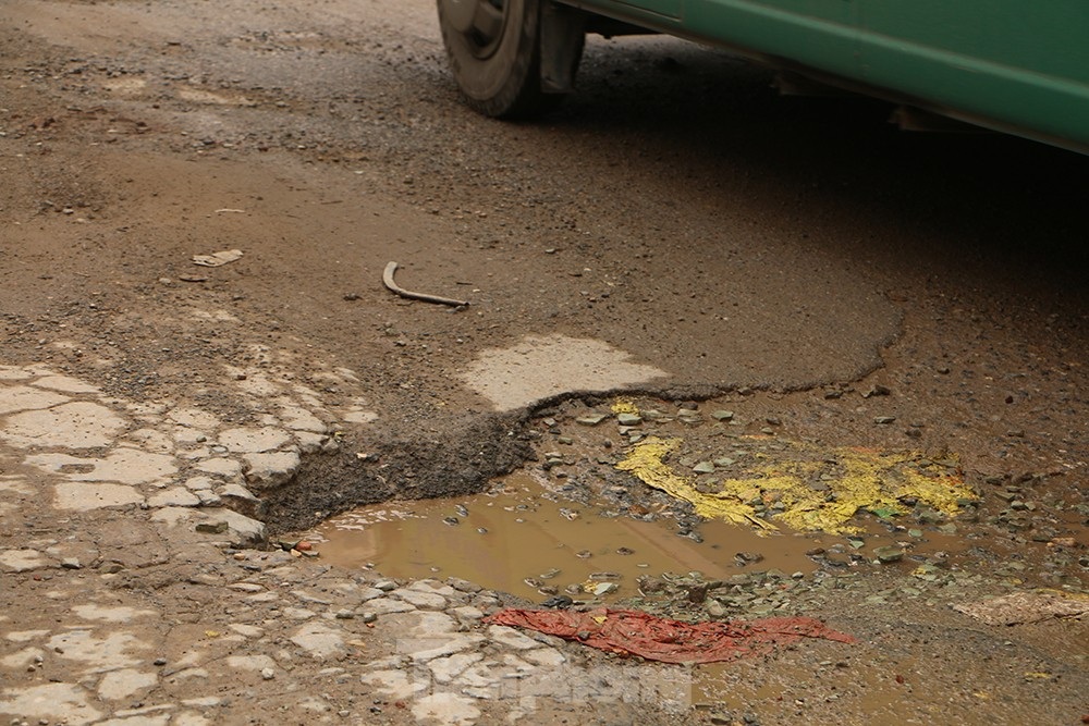 Mặt đường vỡ nát, bong tróc tạo thành hố.
