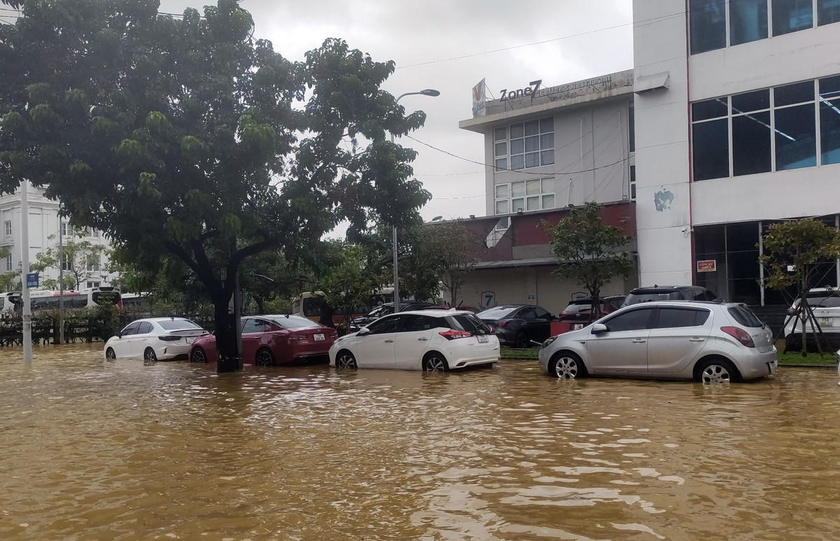 Nhiều ôtô của người dân bị hư hỏng do ngập nước trên đường Hùng Vương, đang chờ xe cứu hộ lai dắt về garage.