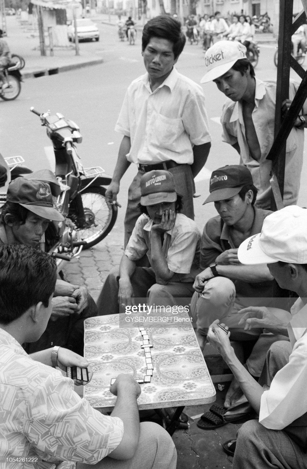 Một nhóm đàn ông tụ tập chơi domino trên đường phố.