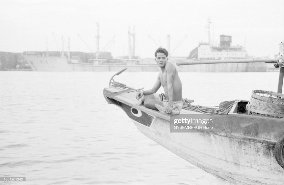 Người thanh niên trên mũi một chiếc ghe ở sông Sài Gòn.
