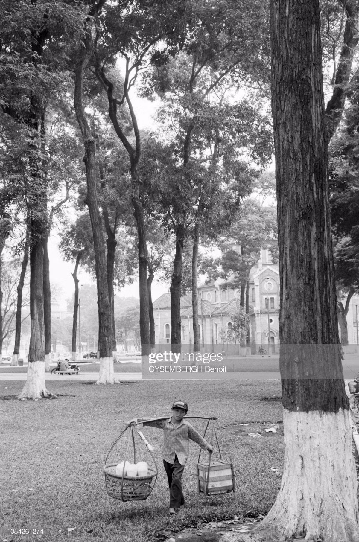 Cậu bé bán hàng rong ở công viên 30 Tháng 4, phía xa là nhà thờ Đức Bà.