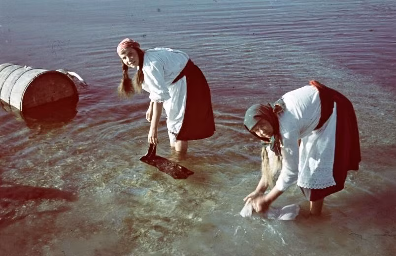 Những người phụ nữ giặt đồ ở bờ sông.