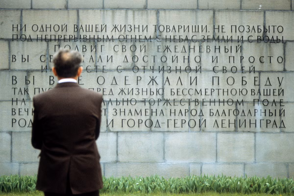 Một người đàn ông đọc những dòng tưởng niệm tại nghĩa trang.