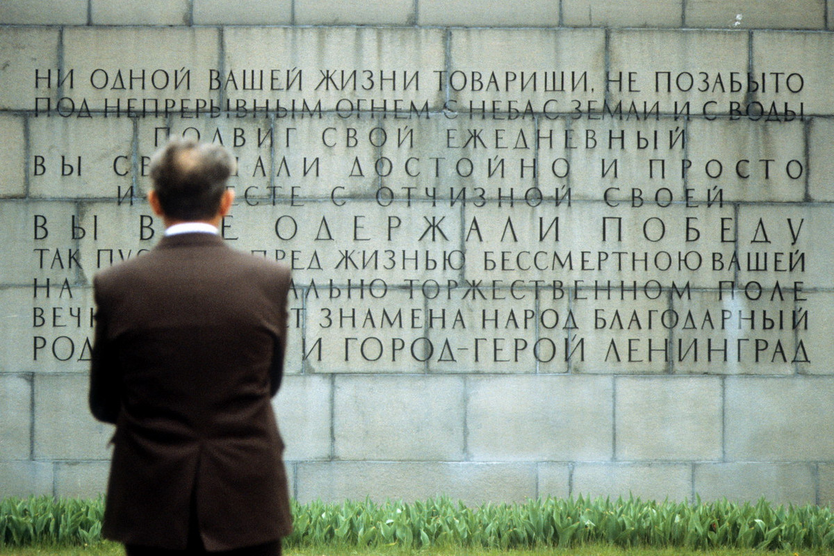 Một người đàn ông đọc những dòng tưởng niệm tại nghĩa trang.