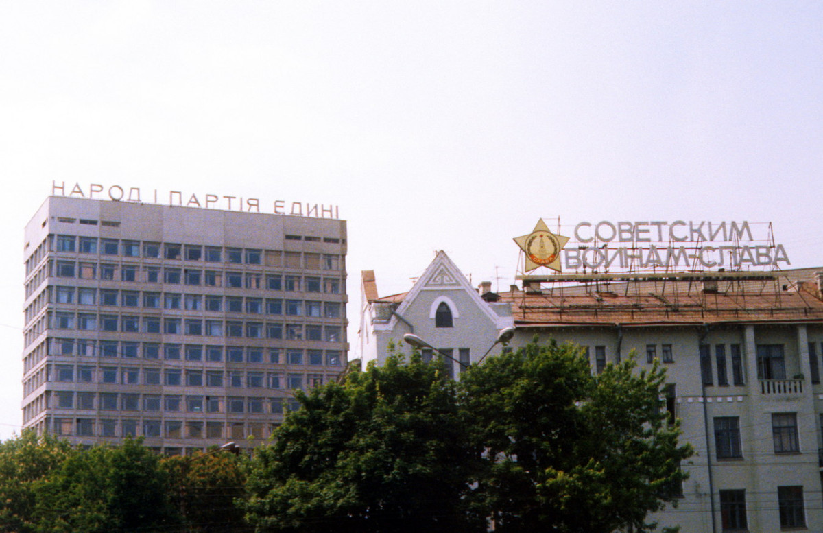Một góc thành phố Kiev với những tòa nhà gắn khẩu hiệu tuyên truyền trên nóc: "Nhân dân và Đảng đoàn kết" (trái); "Xô-viết - Vinh quang cho người lính" (phải).