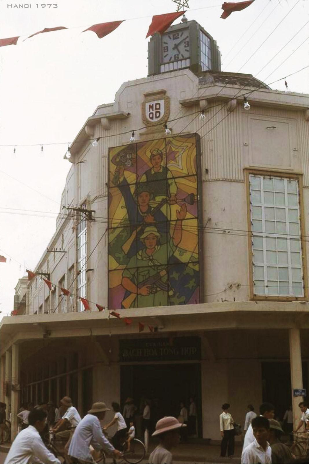 Mặt tiền Bách hóa tổng hợp Tràng Tiền, 1973. Trên cổng có phù điêu "MDQD" (Mậu dịch quốc doanh) và tranh cổ động cho cuộc kháng chiến chống Mỹ.