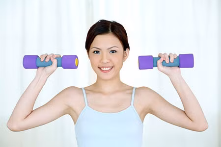 Bài tập tạo khe ngực. Cầm hai quả tạ con khoảng 2 kg, cánh tay vuông góc với mặt đất. Hai tay bắt chéo hai quả tạ 15 lần. Lặp lại động tác này hai lần.