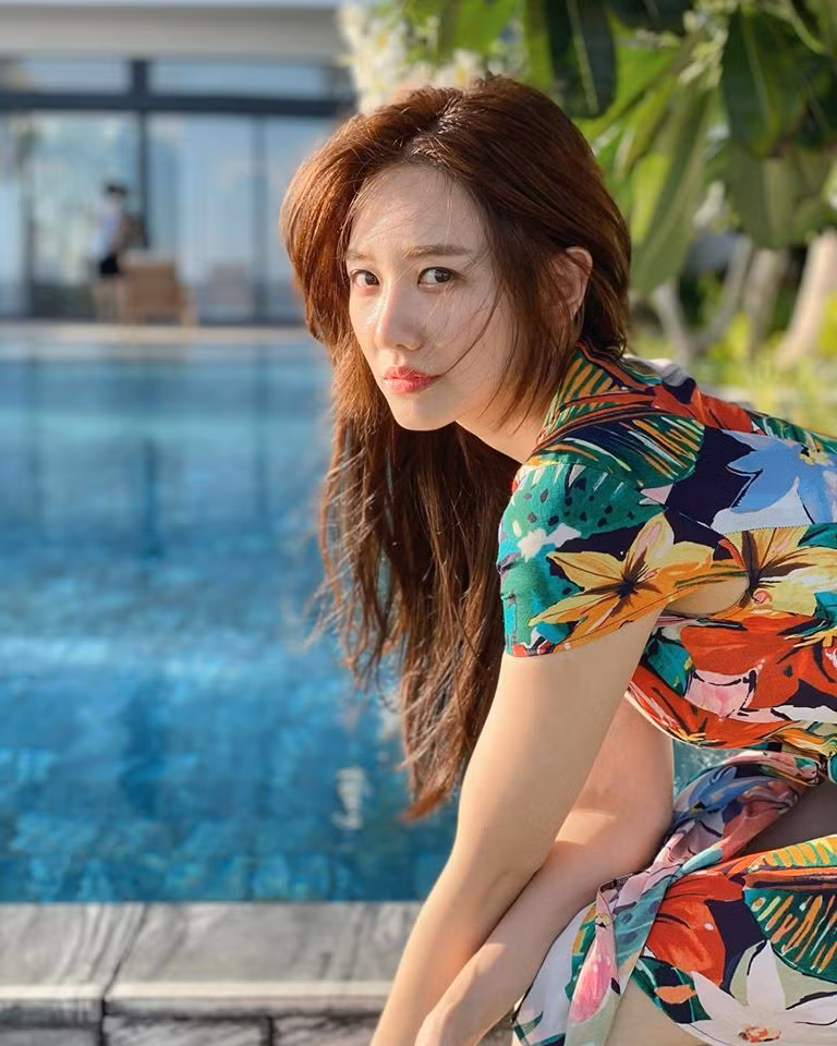 Cô diện chiếc váy hoa sặc sỡ với phong cách mùa hè, mái tóc buông xõa không tạo kiểu.