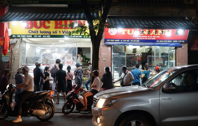 Theo ghi nhận, từ khi Hà Nội nới lỏng một số biện pháp phòng dịch tại các khu vực "vùng xanh", lượng người dân ra đường trên các tuyến phố tăng đột biến, một số hàng quán xuất hiện tình trạng chưa bảo đảm giãn cách. Trong ảnh: Một số người dân đứng dưới lòng đường khiến các phương tiện tham gia giao thông khó khăn trong việc di chuyển