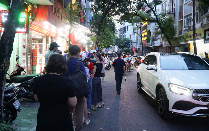 "Khách đến mua hàng không để xe đúng chỗ, toàn để dưới lòng đường, cộng thêm việc rất đông người dân xếp hàng cũng ở lòng đường khiến cho giao thông đi lại khó khăn và cũng tiềm ẩn các nguy cơ lây lan dịch bệnh"- chị Nga cho hay. Trong ảnh: Lực lượng chức năng đã có mặt phân luồng phương tiện tham gia giao thông