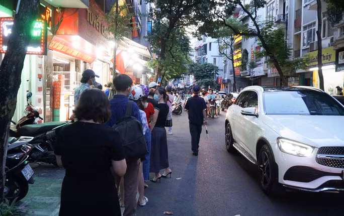 "Khách đến mua hàng không để xe đúng chỗ, toàn để dưới lòng đường, cộng thêm việc rất đông người dân xếp hàng cũng ở lòng đường khiến cho giao thông đi lại khó khăn và cũng tiềm ẩn các nguy cơ lây lan dịch bệnh"- chị Nga cho hay. Trong ảnh: Lực lượng chức năng đã có mặt phân luồng phương tiện tham gia giao thông