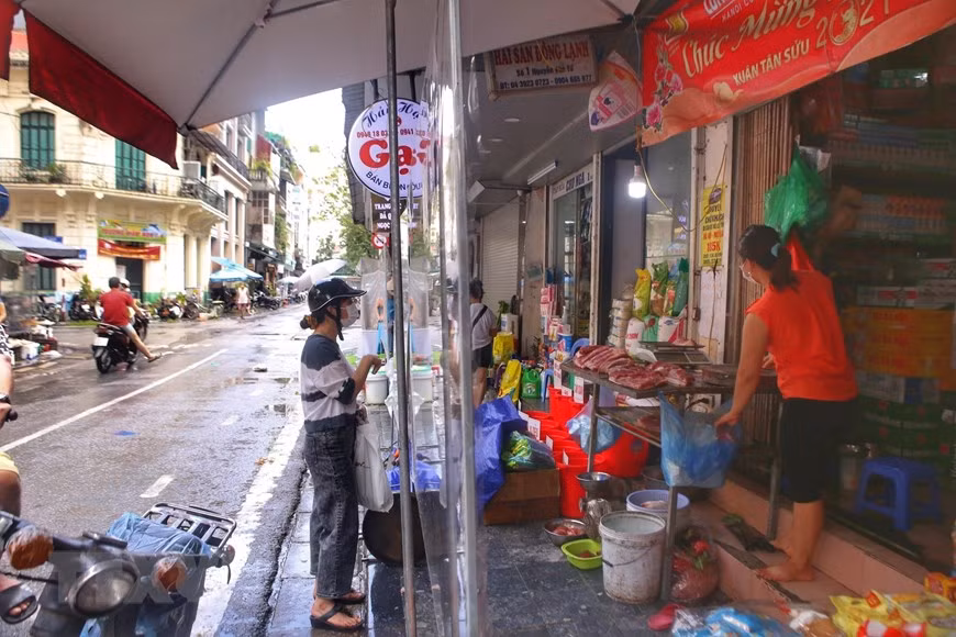  Chợ dân sinh trên phố Nguyễn Văn Tố (Hoàn Kiếm) có vách ngăn đảm bảo khoảng cách giữa người bán và người mua.(Ảnh: Tuấn Đức/TTXVN)